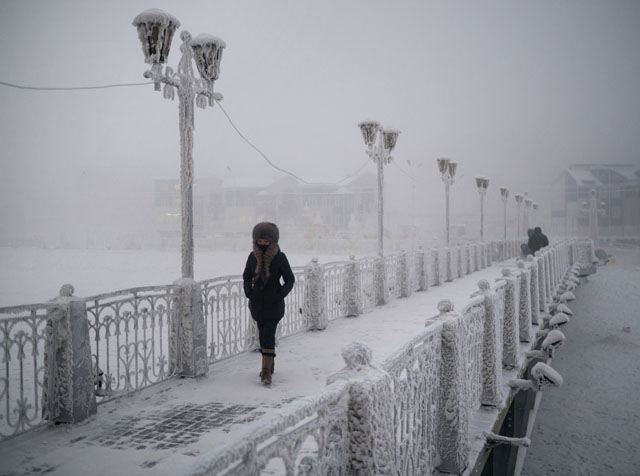 عکاسی در سردترین نقطه کره زمین - عکاسی از یک زن بر روی پل یخ زده یخوتسک قدم می زند.