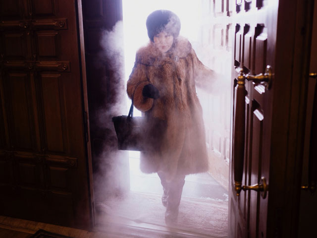 عکاسی در سردترین نقطه کره زمین - عکاسی از یک زن محلی همراه غبار انجماد وارد کلیسای جامع Preobrazhensky می شود.